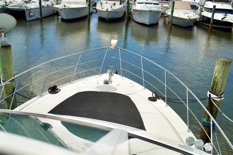Slide: The Image of 1999 Carver 450 Voyager Pilothouse yacht docked at marina, surrounded by other boats. - 8