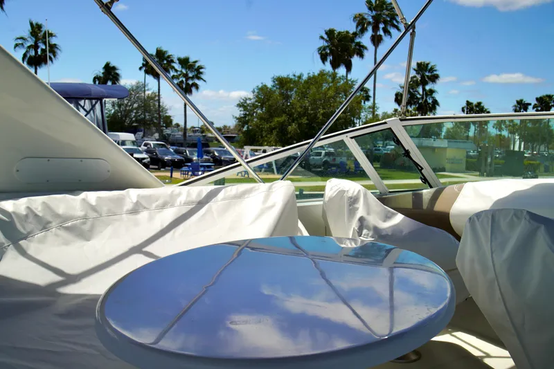 Slide: The Image of 1999 Carver 450 Voyager Pilothouse deck with table, palm trees in background. - 81