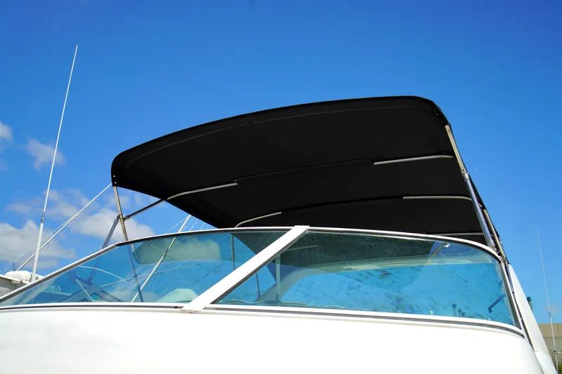 Slide: The Image of 1999 Carver 450 Voyager Pilothouse boat with black canopy against blue sky. - 82