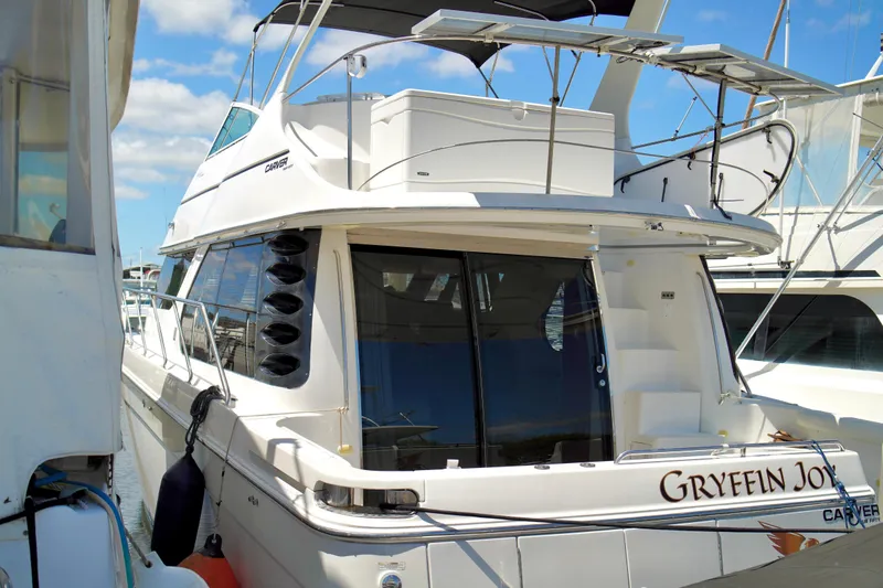Slide: The Image of 1999 Carver 450 Voyager Pilothouse yacht docked at marina under blue sky. - 86