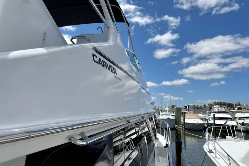 Slide: The Image of 1999 Carver 450 Voyager Pilothouse yacht docked under a blue sky. - 87
