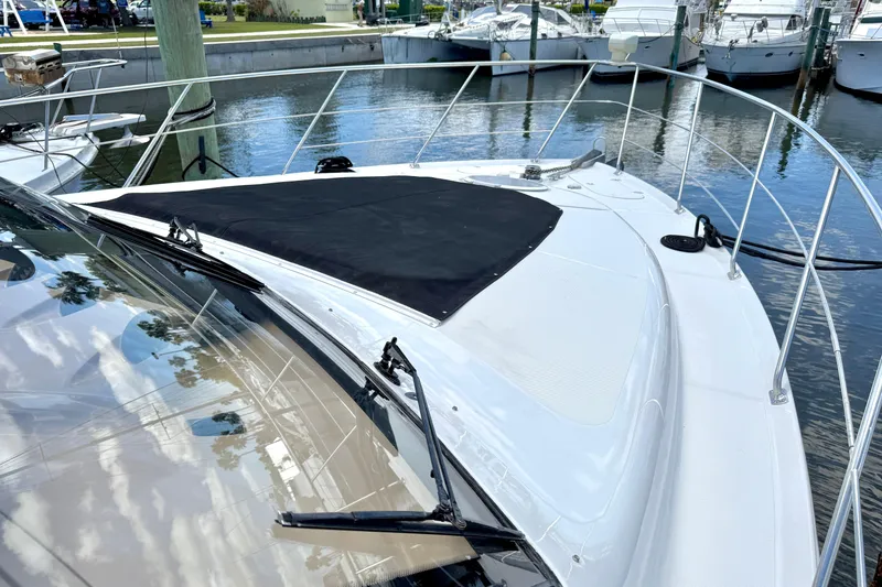 Slide: The Image of 1999 Carver 450 Voyager Pilothouse yacht docked at marina, featuring sleek design and spacious deck. - 9