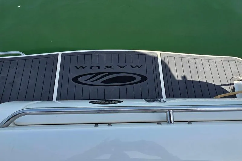 Slide: The Image of 2004 Maxum 3100 SE boat deck with logo, floating on green water. - 10