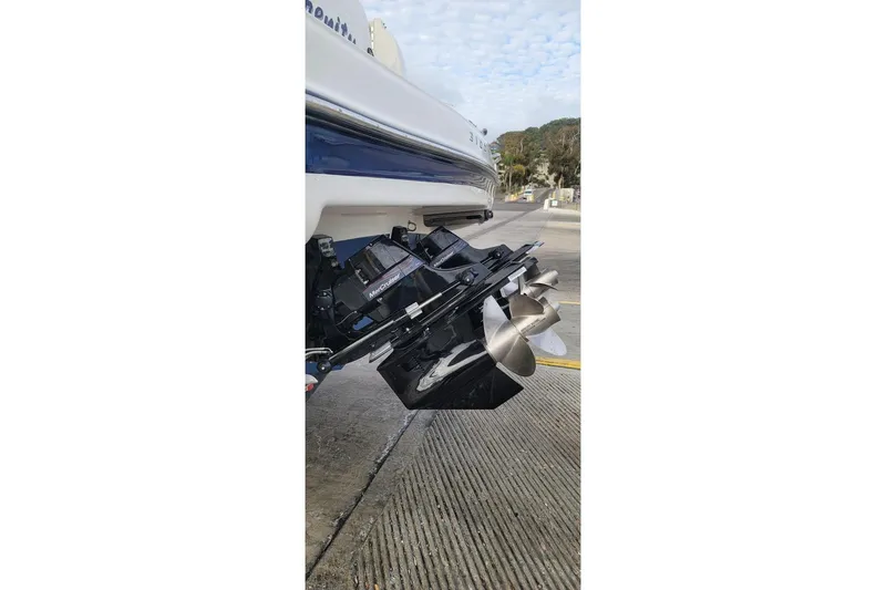 Slide: The Image of 2004 Maxum 3100 SE boat with MerCruiser outdrive and dual propellers on a concrete surface. - 12