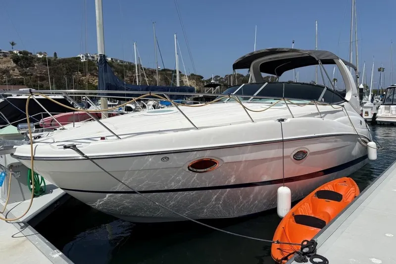 Slide: The Image of 2004 Maxum 3100 SE boat docked with an orange kayak beside it. - 2
