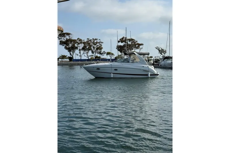 Slide: The Image of 2004 Maxum 3100 SE boat docked in a marina with trees in the background. - 7