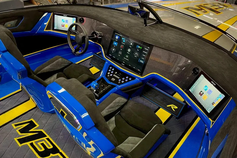 Slide: The Image of Interior of a 2022 DCB M37 boat with advanced digital dashboard and blue accents. - 13