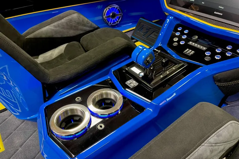 Slide: The Image of Interior of a 2022 DCB M37 boat featuring blue console and modern controls. - 14