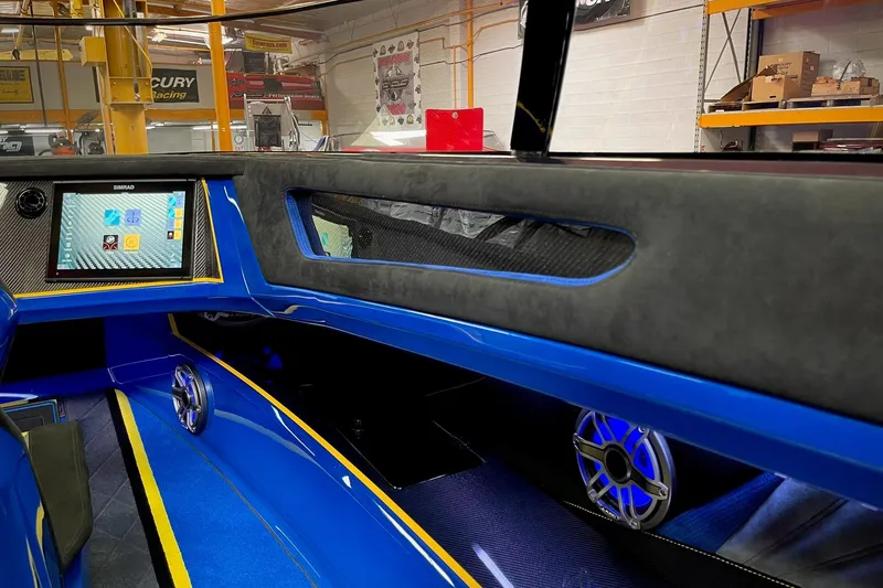 Slide: The Image of Interior of a 2022 DCB M37 boat featuring a modern dashboard and vibrant blue accents. - 17