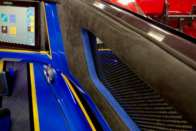 Slide: The Image of Interior of a 2022 DCB M37 boat featuring a Simrad display and sleek blue accents. - 18