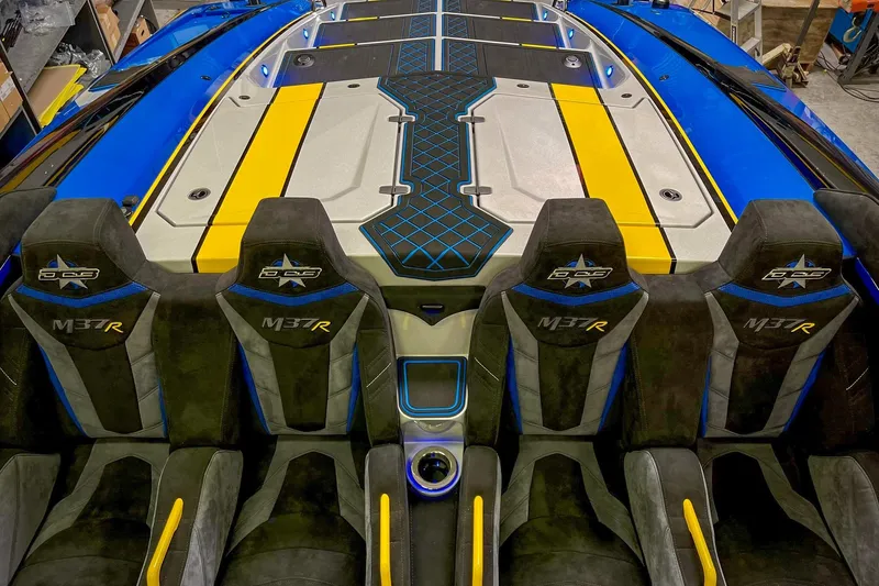 Slide: The Image of 2022 DCB M37 boat interior with custom seats and vibrant blue and yellow accents. - 25