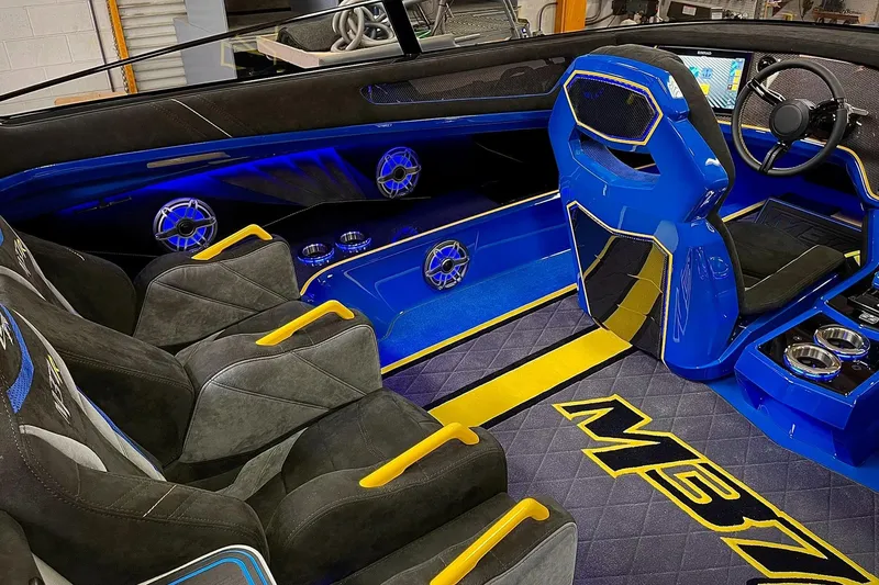 Slide: The Image of Interior of a 2022 DCB M37 boat with blue and yellow accents, luxury seating, and advanced controls. - 3