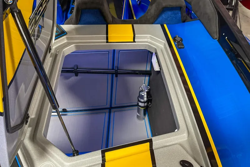 Slide: The Image of Open storage compartment on a 2022 DCB M37 boat, featuring vibrant blue and yellow accents. - 8