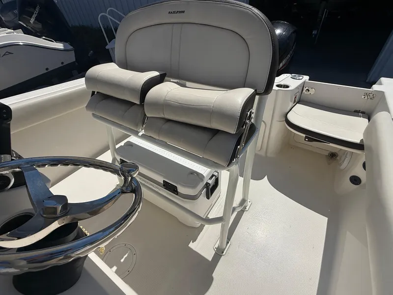 Slide: The Image of 2023 Sailfish 220 CC boat interior with steering wheel and cushioned seating. - 14