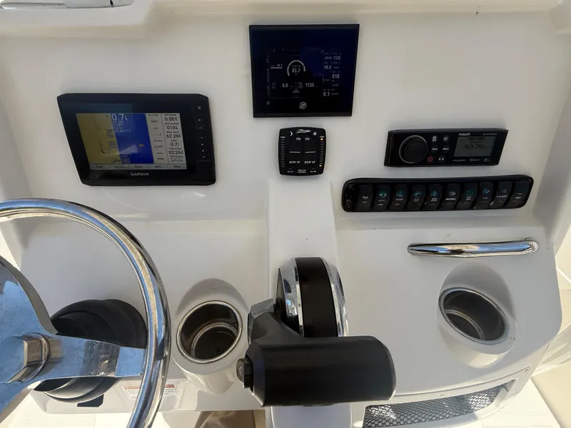 Slide: The Image of 2023 Sailfish 220 CC boat dashboard with steering wheel, controls, and electronic displays. - 16