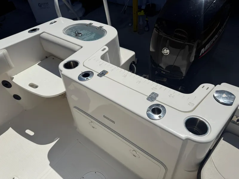Slide: The Image of 2023 Sailfish 220 CC boat interior with fishing rod holders and storage compartments. - 21