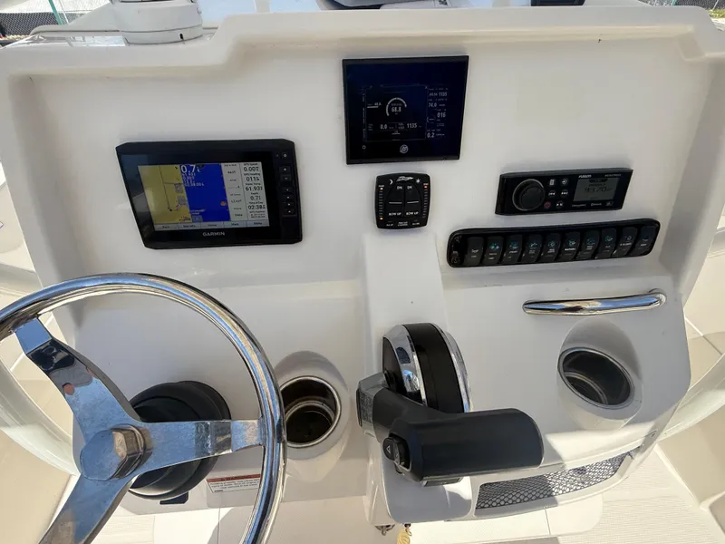 Slide: The Image of 2023 Sailfish 220 CC boat dashboard with steering wheel, controls, and navigation displays. - 29