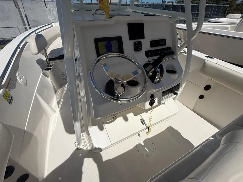 Slide: The Image of 2023 Sailfish 220 CC boat console with steering wheel and navigation controls. - 37