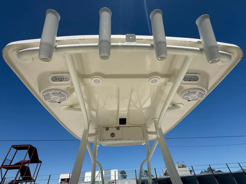 Slide: The Image of 2023 Sailfish 220 CC boat top view with rod holders and speakers against blue sky. - 39