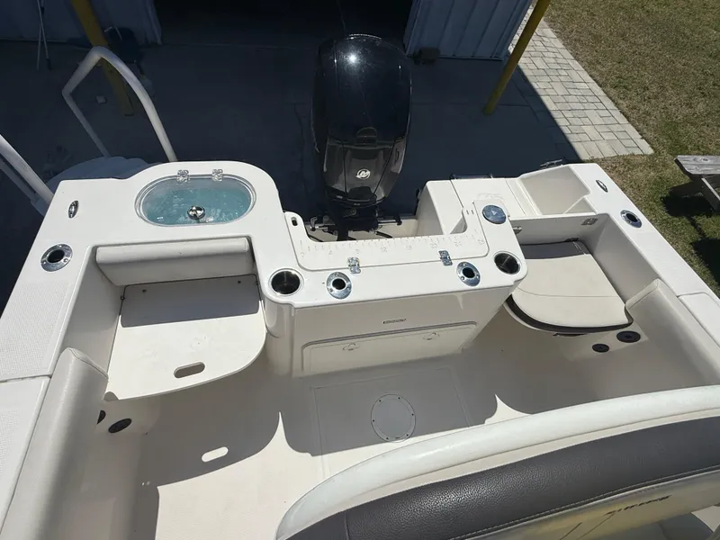 Slide: The Image of 2023 Sailfish 220 CC boat deck with seating, storage, and motor. - 41