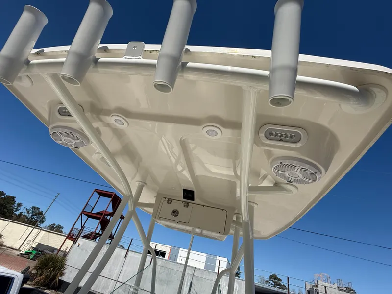Slide: The Image of 2023 Sailfish 220 CC boat top view with rod holders and speakers against blue sky. - 5