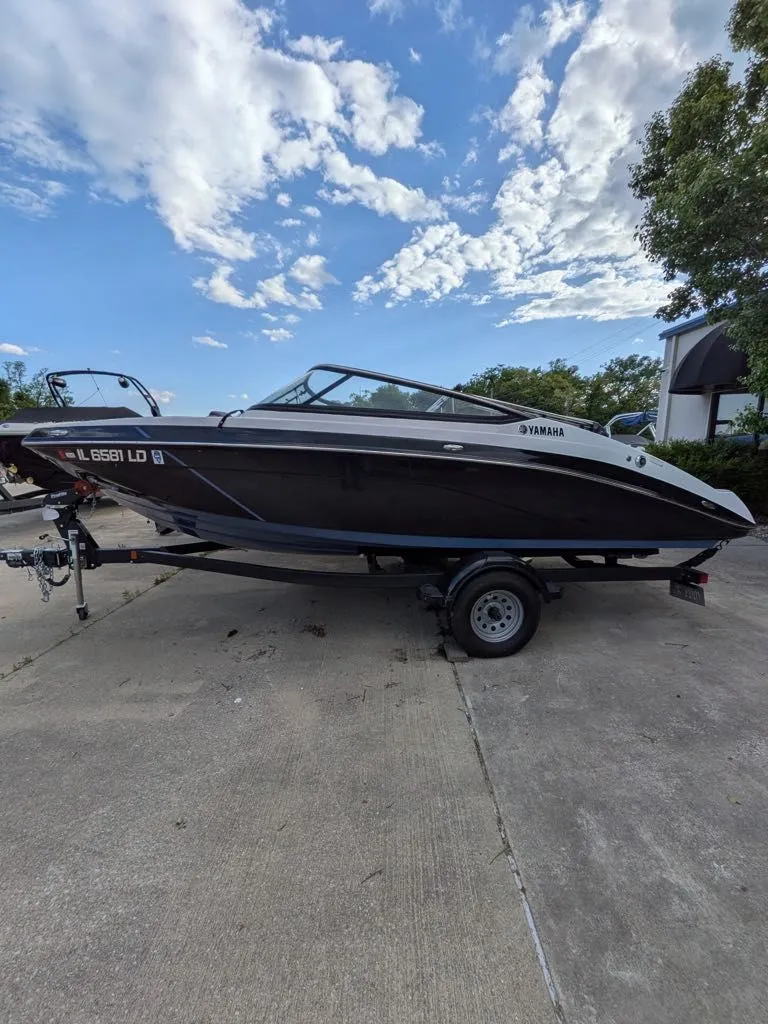 Slide: The Image of 2023 Yamaha SX195 boat on trailer under blue sky. - 6