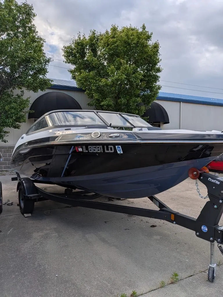 Slide: The Image of 2023 Yamaha SX195 boat on trailer in front of building. - 8