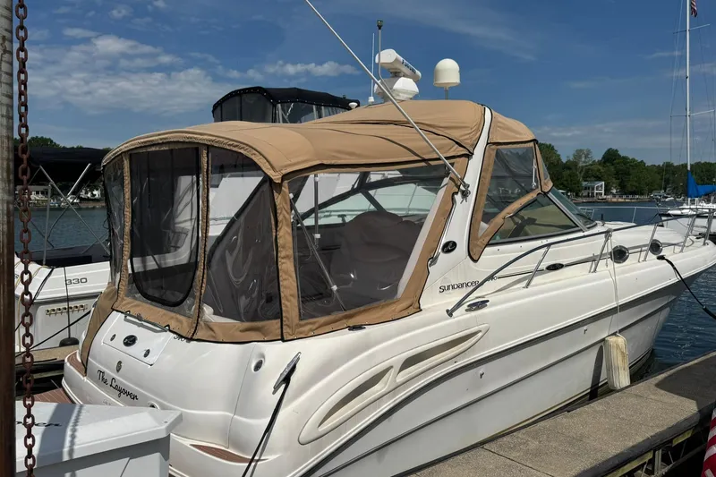 The Image of 2001 Sea Ray 340 Sundancer docked with tan canopy, under clear blue sky. - 0