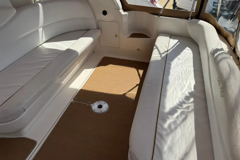 Slide: The Image of Interior of a 2001 Sea Ray 340 Sundancer boat with white seating and brown flooring. - 13