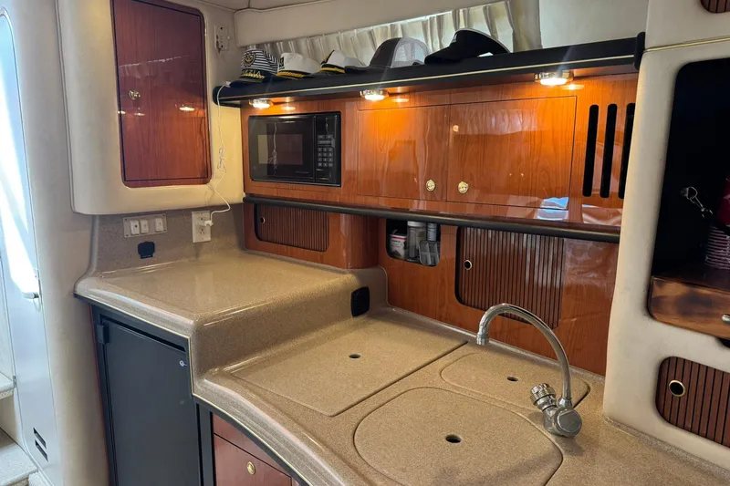 Slide: The Image of Interior of 2001 Sea Ray 340 Sundancer yacht with kitchenette and wooden cabinetry. - 32
