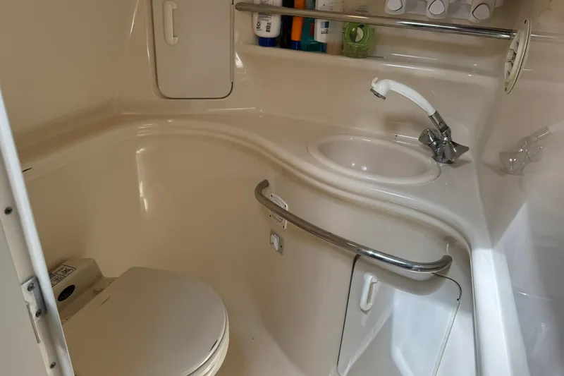 Slide: The Image of 2001 Sea Ray 340 Sundancer bathroom with sink, toilet, and storage shelves. - 35