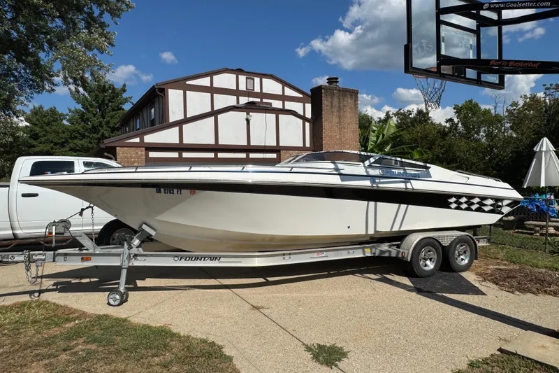 The Image of 2004 Fountain 27 Fever boat on trailer, parked in driveway near house and basketball hoop. - 1
