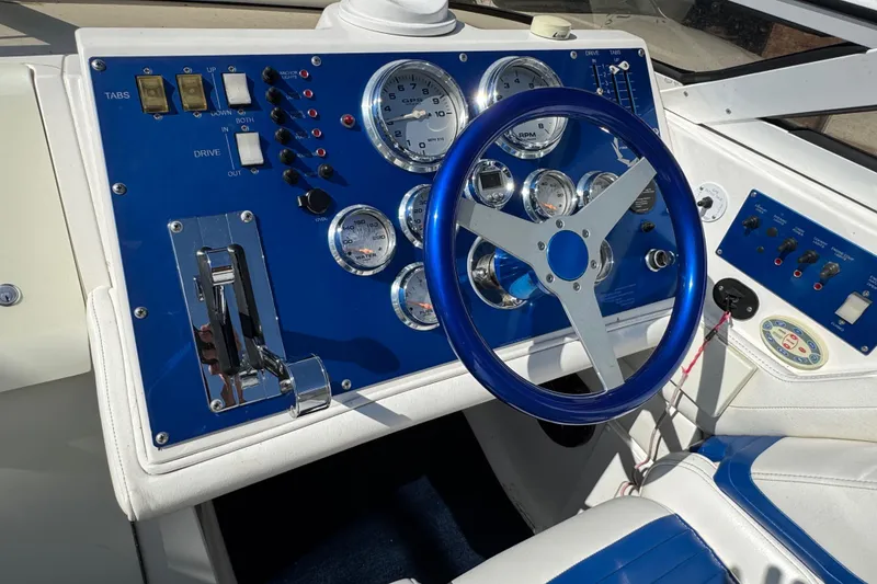 Slide: The Image of 2004 Fountain 27 Fever boat dashboard with blue steering wheel and control panel. - 17