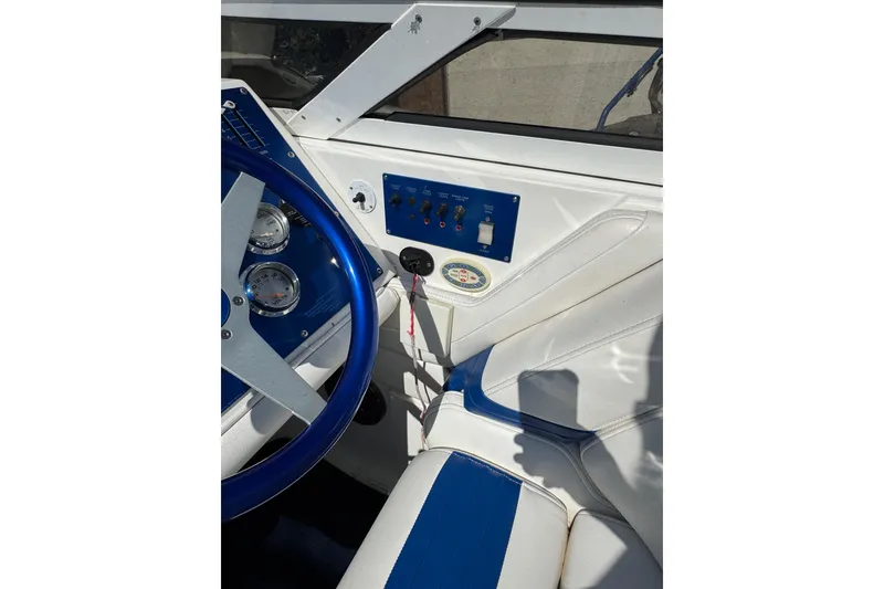 Slide: The Image of 2004 Fountain 27 Fever boat cockpit with blue steering wheel and white seating. - 20