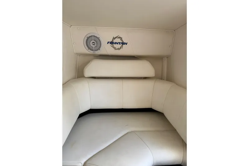Slide: The Image of 2004 Fountain 27 Fever boat interior with white cushioned seating and speaker. - 34