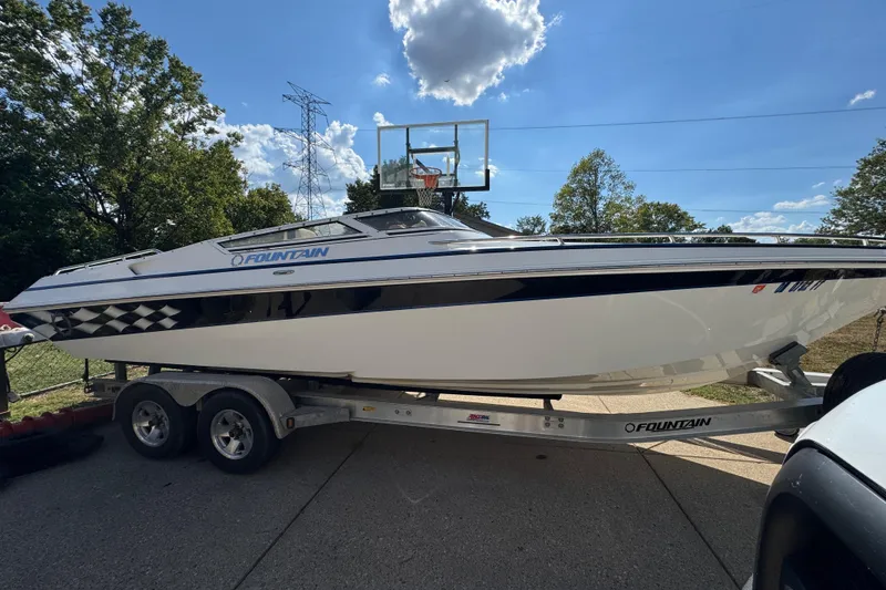 Slide: The Image of 2004 Fountain 27 Fever boat on trailer, parked outdoors under a blue sky. - 6