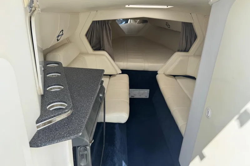 Slide: The Image of Interior of a 2004 Fountain 35 Lightning boat with white seating and compact kitchenette. - 20