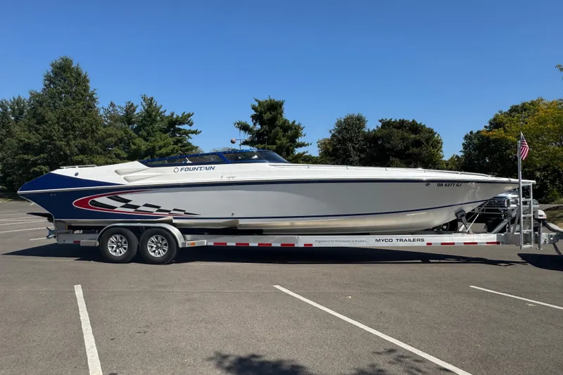 Slide: The Image of 2004 Fountain 35 Lightning boat on trailer in parking lot, surrounded by trees. - 8