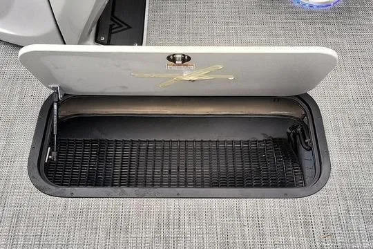 Slide: The Image of Open storage compartment in 2026 Viaggio x22u boat, featuring a textured interior and secure latch. - 13