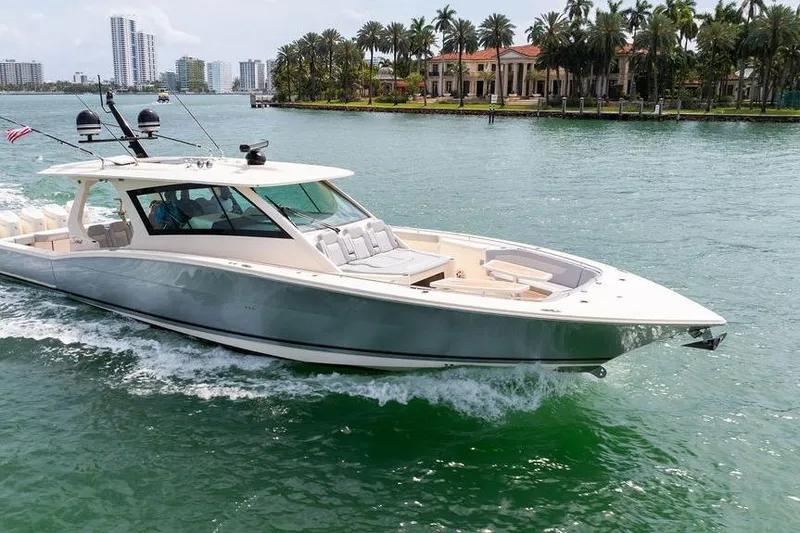 Slide: The Image of 2020 Scout 530 LXF luxury yacht cruising in tropical waters near palm-lined shore. - 10