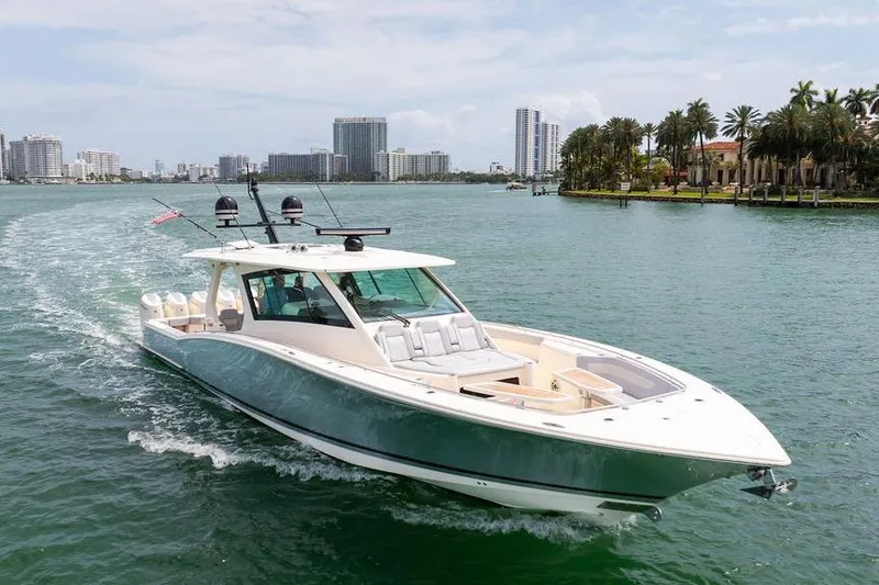 Slide: The Image of 2020 Scout 530 LXF luxury yacht cruising in a scenic waterfront cityscape. - 12