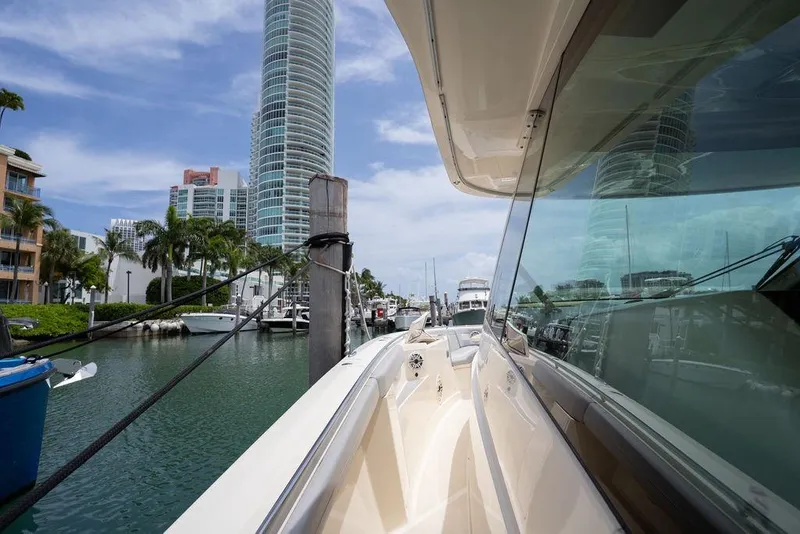 Slide: The Image of 2020 Scout 530 LXF yacht docked in a marina with modern buildings. - 132