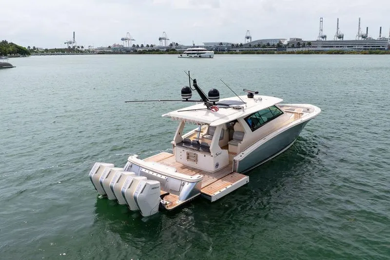 Slide: The Image of 2020 Scout 530 LXF luxury boat with multiple engines on calm water. - 23