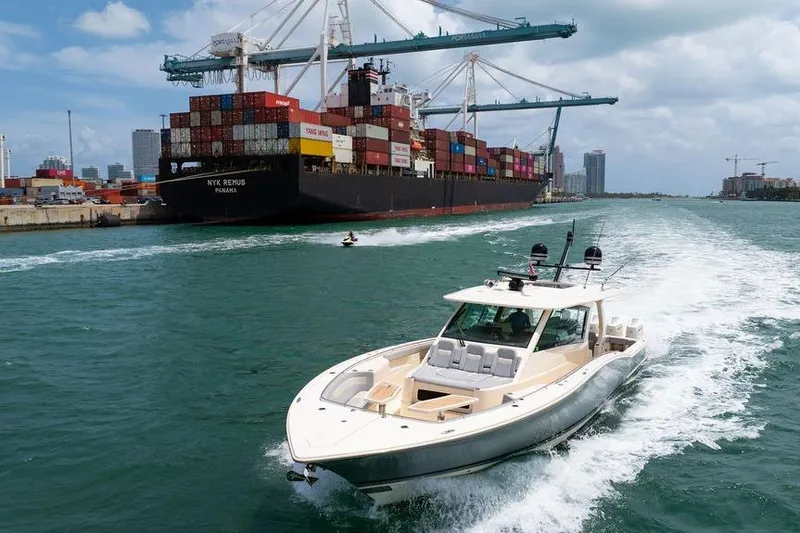 Slide: The Image of 2020 Scout 530 LXF cruising near a container ship in a busy harbor. - 28