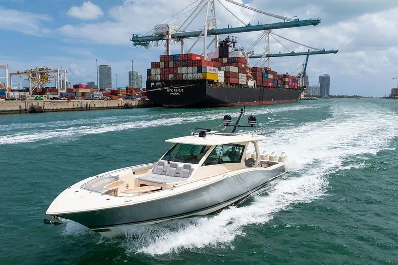 Slide: The Image of 2020 Scout 530 LXF yacht cruising near a busy shipping port. - 29