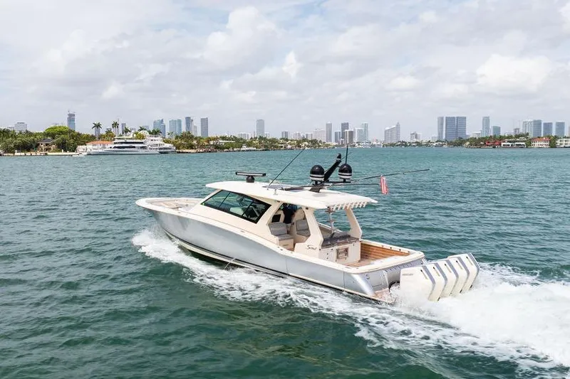 Slide: The Image of 2020 Scout 530 LXF boat cruising on water with city skyline in background. - 44