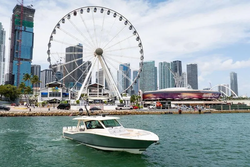 Slide: The Image of 2020 Scout 530 LXF boat cruising near a city skyline with a Ferris wheel. - 51