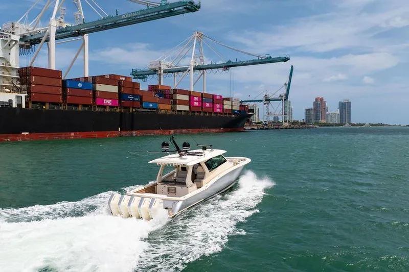 Slide: The Image of 2020 Scout 530 LXF boat cruising near cargo ship and cranes in harbor. - 53