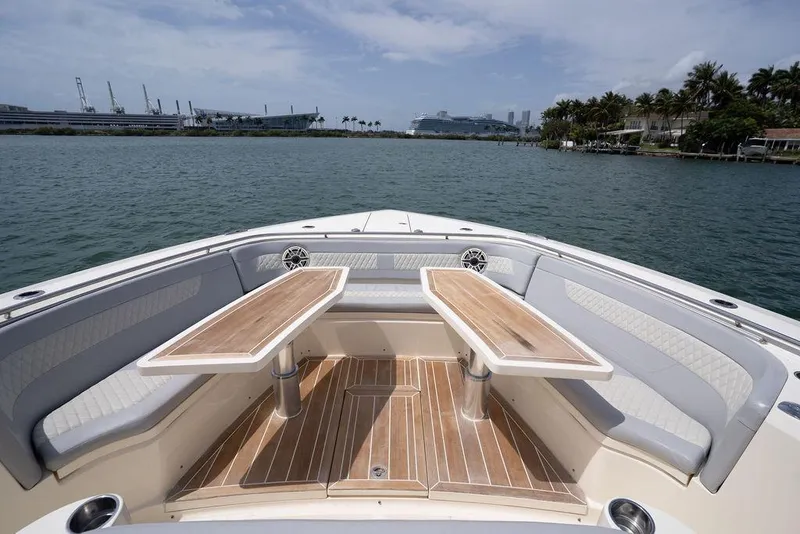Slide: The Image of 2020 Scout 530 LXF boat interior with elegant seating and wooden tables on the water. - 61