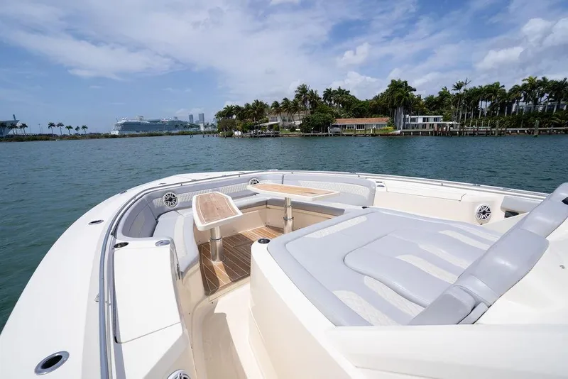 Slide: The Image of Luxurious 2020 Scout 530 LXF yacht cruising near waterfront homes and palm trees. - 67